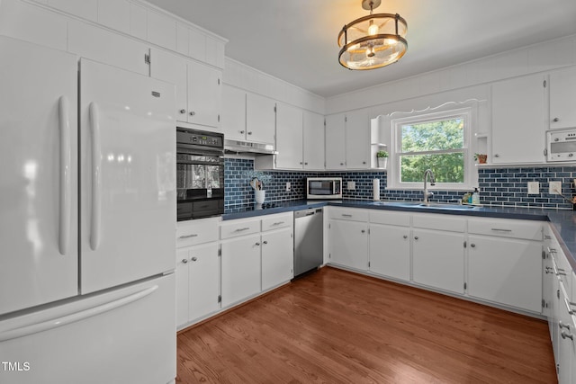 12082 NC-42, Fuquay Varina, NC 27526 - kitchen featuring appliances with stainless steel finishes, dark countertops, white cabinetry, and under cabinet range hood