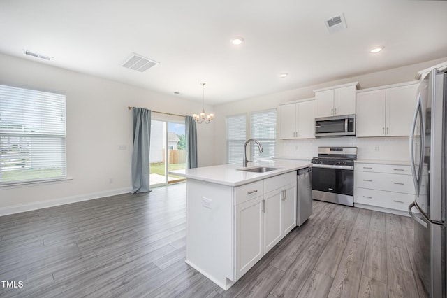 80 Nailsworth St, Angier, NC 27501 - kitchen with appliances with stainless steel finishes, a chandelier, backsplash, a center island with sink, and light wood-style floors