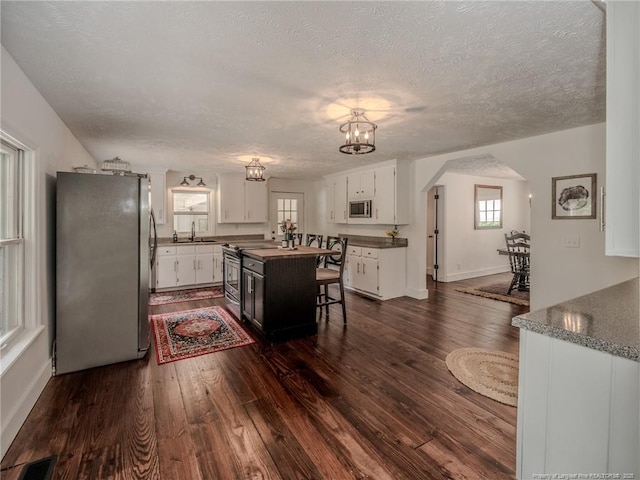 1554 Locklear Rd, Pembroke, NC 28372 - kitchen featuring stainless steel appliances, white cabinetry, a chandelier, dark wood-style flooring, and dark countertops
