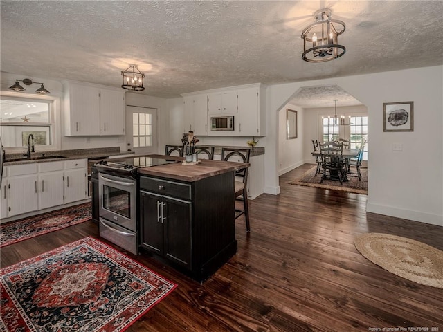 1554 Locklear Rd, Pembroke, NC 28372 - kitchen with a chandelier, appliances with stainless steel finishes, a textured ceiling, butcher block counters, and arched walkways