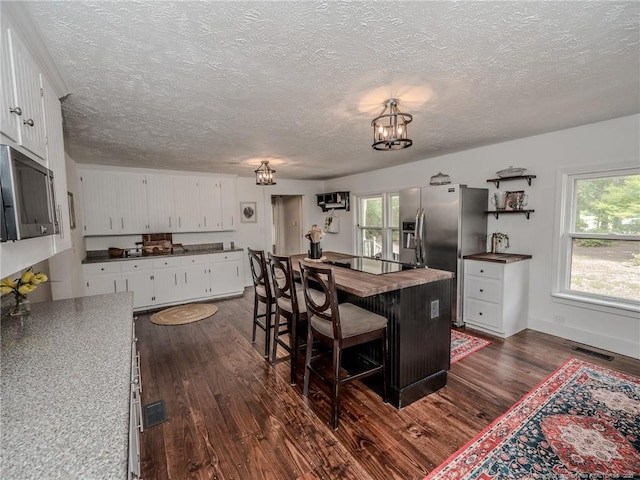 1554 Locklear Rd, Pembroke, NC 28372 - kitchen featuring butcher block countertops, appliances with stainless steel finishes, dark wood-type flooring, a chandelier, and white cabinetry