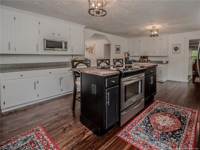 1554 Locklear Rd, Pembroke, NC 28372 - kitchen with stainless steel appliances, dark cabinetry, a textured ceiling, white cabinets, and dark wood-style floors