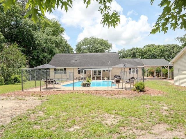 1554 Locklear Rd, Pembroke, NC 28372 - back of house with a carport, a patio, an outdoor pool, and a shingled roof