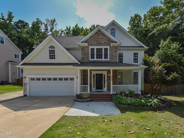 1005 Fairfax Woods Dr, Apex, NC 27502 - view of front of home featuring stone siding, covered porch, driveway, and a garage