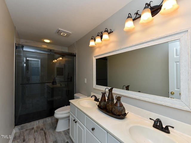 1005 Fairfax Woods Dr, Apex, NC 27502 - bathroom with double vanity, a shower stall, and wood finished floors