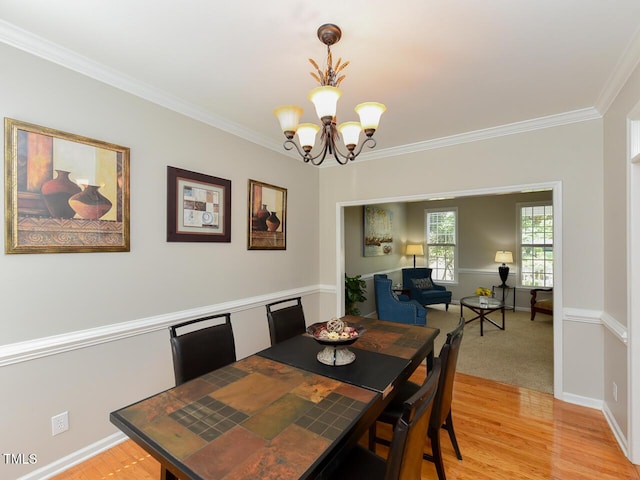 1005 Fairfax Woods Dr, Apex, NC 27502 - dining room featuring a chandelier, ornamental molding, and light wood-style flooring