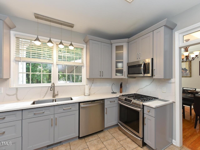 1005 Fairfax Woods Dr, Apex, NC 27502 - kitchen featuring appliances with stainless steel finishes, gray cabinets, backsplash, and glass insert cabinets