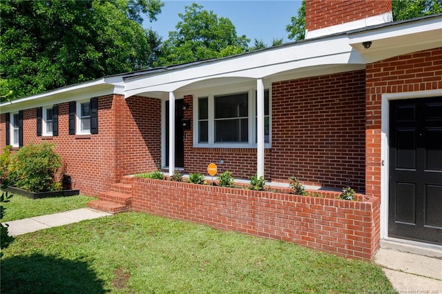 106 N 3rd St, Maxton, NC 28364 - view of front of property featuring brick siding, a chimney, and a front lawn