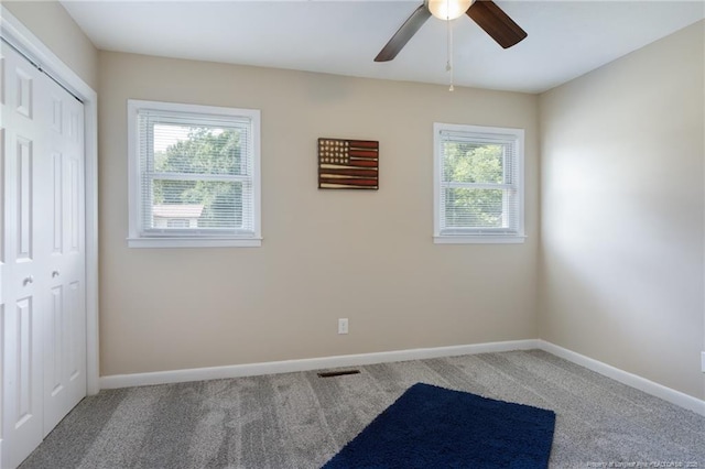 106 N 3rd St, Maxton, NC 28364 - unfurnished bedroom with carpet floors, a closet, and a ceiling fan