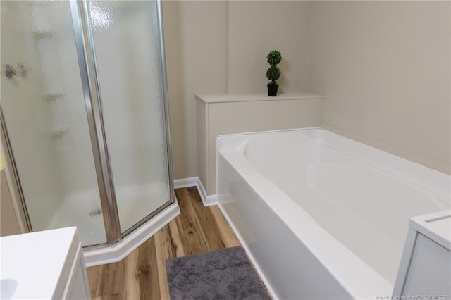 106 N 3rd St, Maxton, NC 28364 - full bath with a stall shower, wood finished floors, a garden tub, and vanity