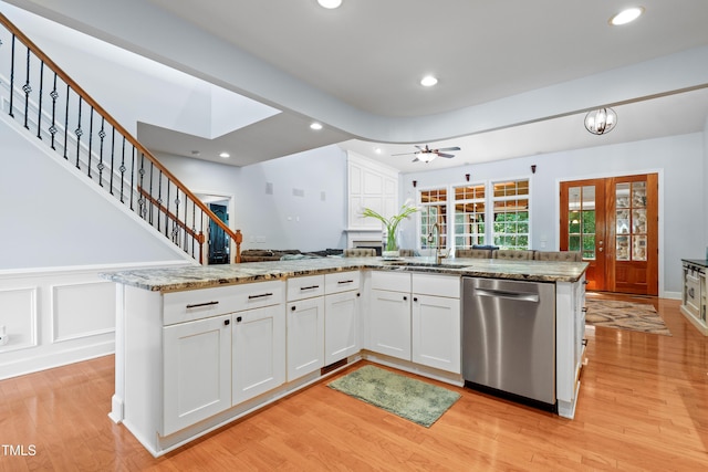 534 Siltstone Pl, Cary, NC 27519 - kitchen with stainless steel dishwasher, light wood finished floors, white cabinetry, recessed lighting, and light stone counters