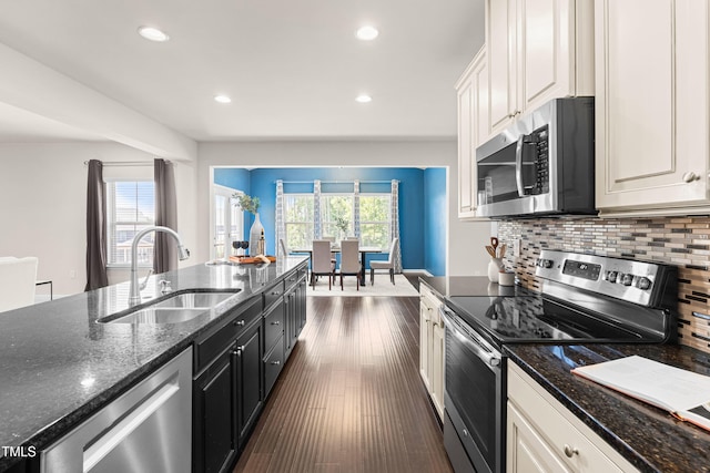 3504 Regent Pines Dr, New Hill, NC 27562 - kitchen featuring appliances with stainless steel finishes, tasteful backsplash, dark stone counters, recessed lighting, and white cabinetry