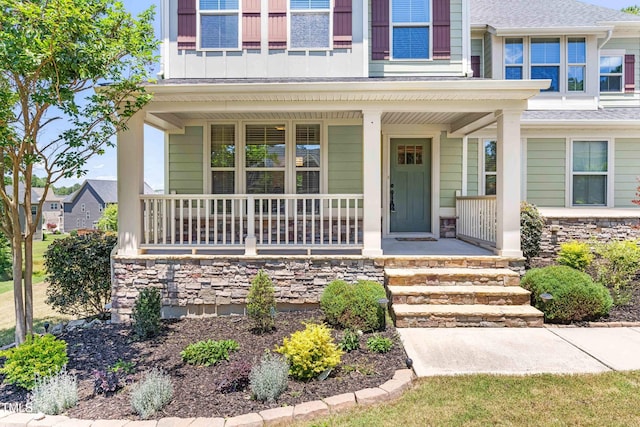 3504 Regent Pines Dr, New Hill, NC 27562 - view of exterior entry with covered porch, stone siding, and a shingled roof