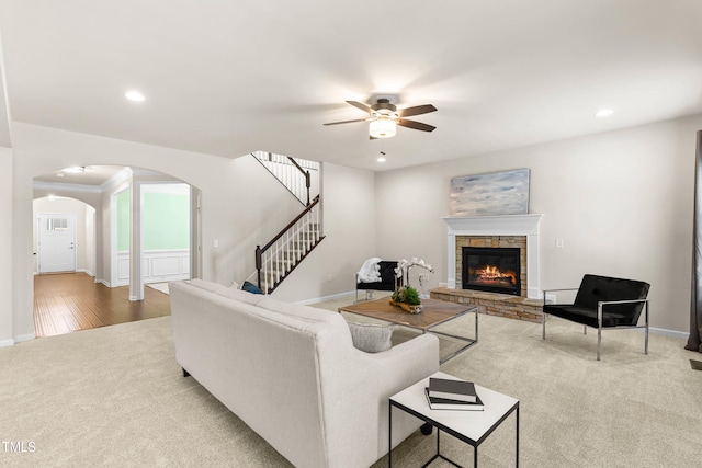 3504 Regent Pines Dr, New Hill, NC 27562 - living area with carpet flooring, arched walkways, a ceiling fan, a fireplace, and stairway