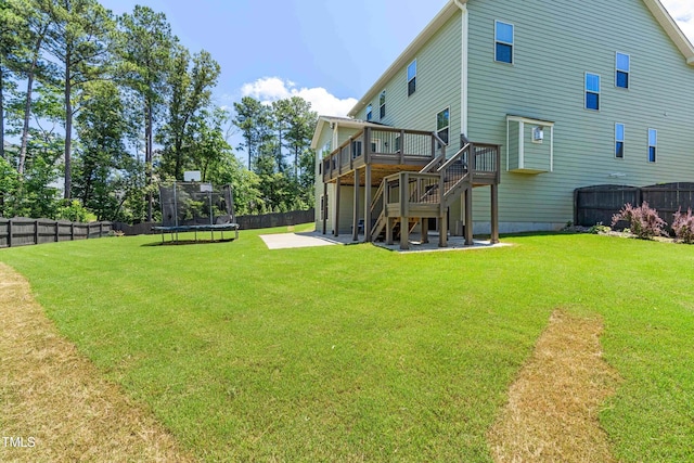 3504 Regent Pines Dr, New Hill, NC 27562 - fenced backyard featuring a trampoline, a patio, a wooden deck, and stairway