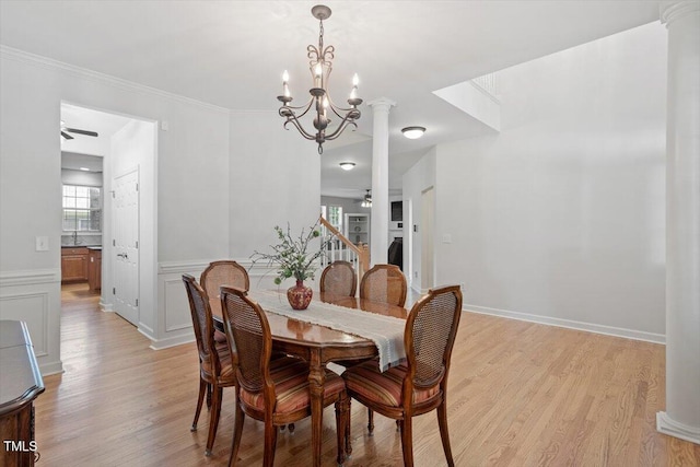 3921 Robins Nest Ln, Wake Forest, NC 27587 - dining space featuring ceiling fan, light wood finished floors, a chandelier, wainscoting, and ornate columns