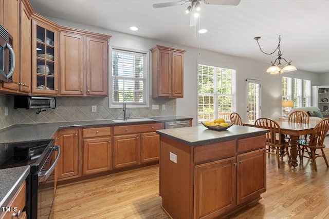 3921 Robins Nest Ln, Wake Forest, NC 27587 - kitchen with appliances with stainless steel finishes, dark countertops, light wood-style flooring, brown cabinetry, and recessed lighting