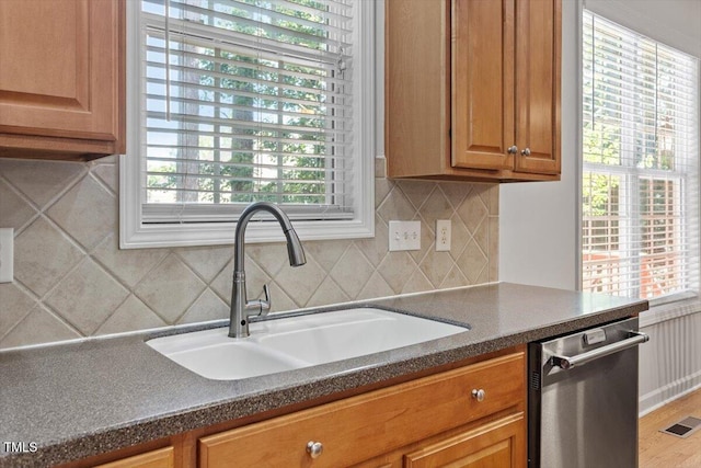 3921 Robins Nest Ln, Wake Forest, NC 27587 - kitchen featuring dishwasher, tasteful backsplash, dark countertops, and brown cabinetry