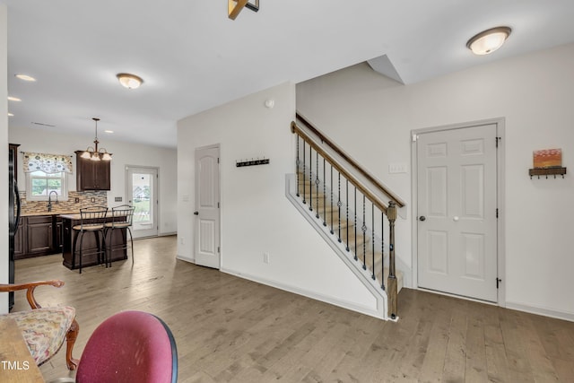 48 Manito Pl, Clayton, NC 27520 - living area with stairway, light wood-type flooring, and a chandelier