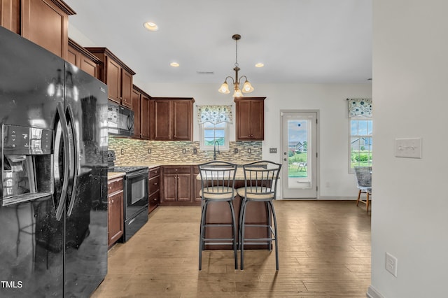 48 Manito Pl, Clayton, NC 27520 - kitchen with black appliances, decorative backsplash, light wood finished floors, recessed lighting, and plenty of natural light