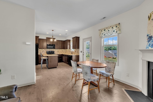 48 Manito Pl, Clayton, NC 27520 - dining room with light wood finished floors, recessed lighting, and a fireplace with flush hearth