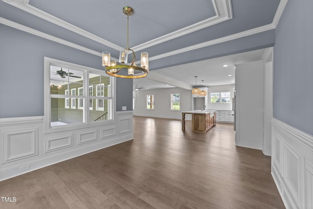 543 Allessandra Dr, Clayton, NC 27527 - unfurnished living room featuring a chandelier, ceiling fan, dark wood finished floors, a wainscoted wall, and ornamental molding
