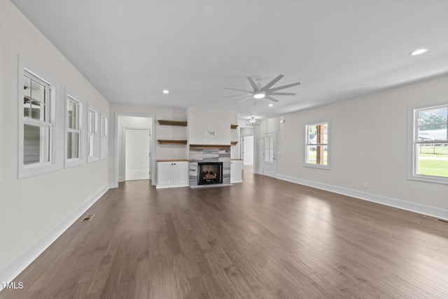 543 Allessandra Dr, Clayton, NC 27527 - unfurnished living room with ceiling fan, a tiled fireplace, plenty of natural light, dark wood finished floors, and recessed lighting
