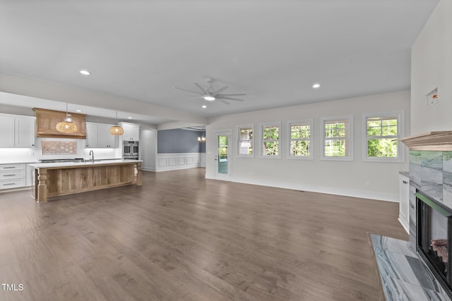 543 Allessandra Dr, Clayton, NC 27527 - unfurnished living room with a fireplace, ceiling fan, dark wood-type flooring, wainscoting, and recessed lighting