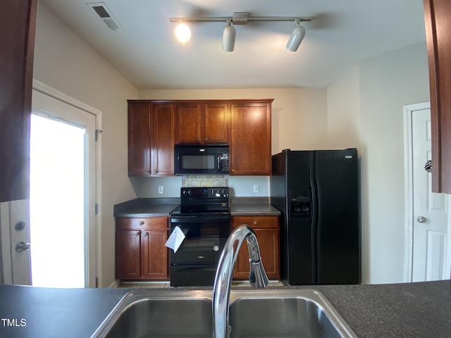 545 Writers Way, Morrisville, NC 27560 - kitchen featuring black appliances, rail lighting, dark countertops, and brown cabinetry