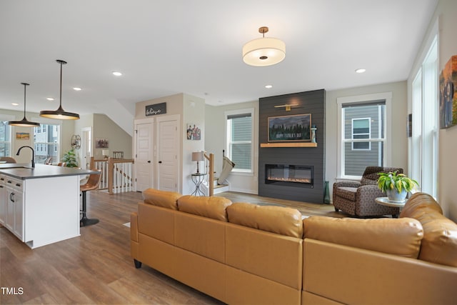 2055 Eva Pearl Dr, Apex, NC 27502 - living area featuring dark wood finished floors, a large fireplace, and recessed lighting