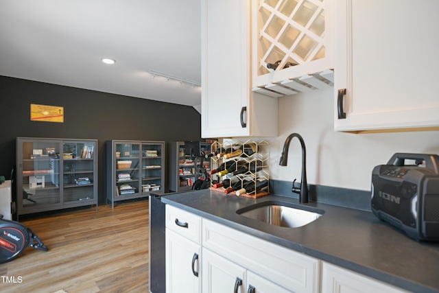 2055 Eva Pearl Dr, Apex, NC 27502 - kitchen featuring dark countertops, white cabinets, light wood finished floors, and rail lighting