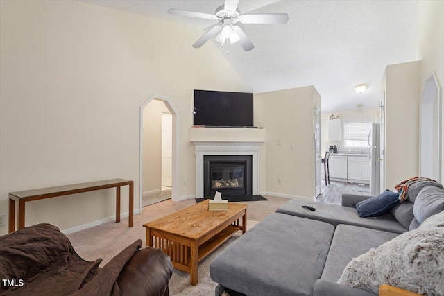 5104 Parkerwood Dr, Knightdale, NC 27545 - living room with arched walkways, ceiling fan, light colored carpet, a fireplace with flush hearth, and high vaulted ceiling