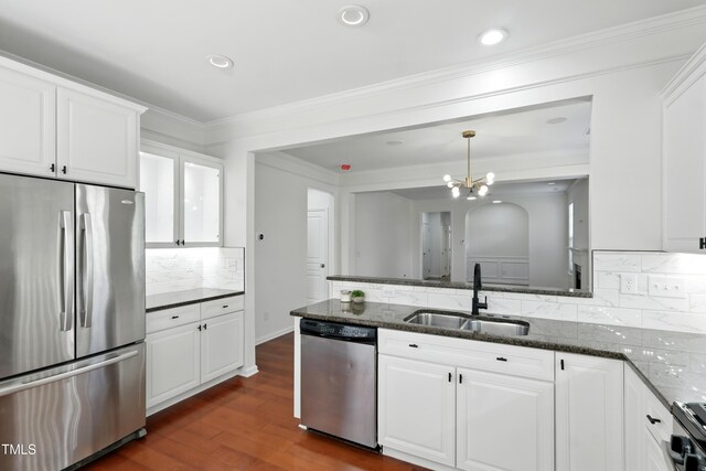 9201 Wooden Rd, Raleigh, NC 27617 - kitchen featuring appliances with stainless steel finishes, white cabinets, backsplash, dark wood-type flooring, and dark stone counters