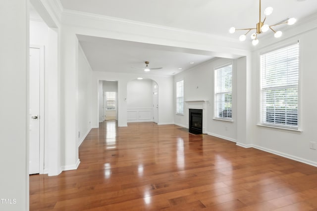 9201 Wooden Rd, Raleigh, NC 27617 - unfurnished living room featuring arched walkways, wood finished floors, ornamental molding, a chandelier, and a fireplace with flush hearth