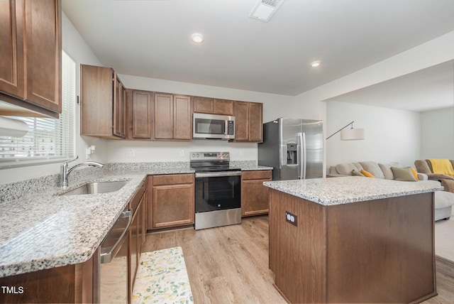 703 Corvette View Knl, Wendell, NC 27591 - kitchen with appliances with stainless steel finishes, light wood finished floors, a center island, light stone counters, and open floor plan