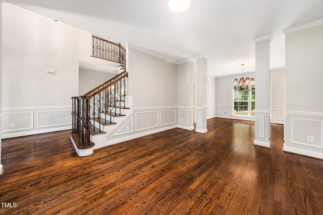 3811 Cottonwood Dr, Durham, NC 27705 - unfurnished living room featuring a chandelier, a decorative wall, ornamental molding, wood finished floors, and stairs