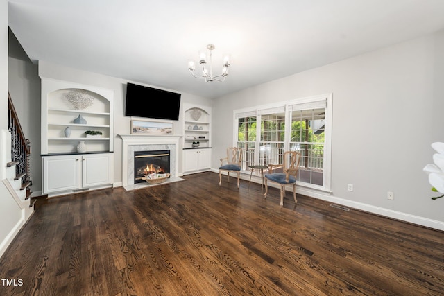 3811 Cottonwood Dr, Durham, NC 27705 - living area with a fireplace, a chandelier, stairs, built in shelves, and dark wood finished floors