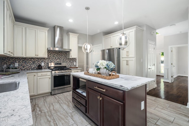 3811 Cottonwood Dr, Durham, NC 27705 - kitchen featuring stainless steel appliances, wall chimney range hood, tasteful backsplash, hanging light fixtures, and light stone counters