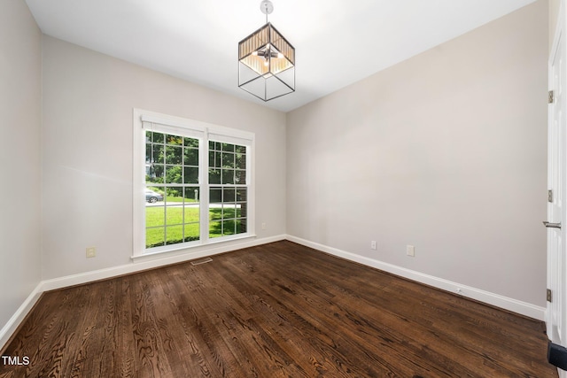 3811 Cottonwood Dr, Durham, NC 27705 - spare room featuring dark wood finished floors and a chandelier