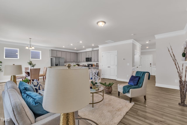 3505 Triad Ct, Raleigh, NC 27604 - living area with ornamental molding, a chandelier, light wood-style floors, and recessed lighting