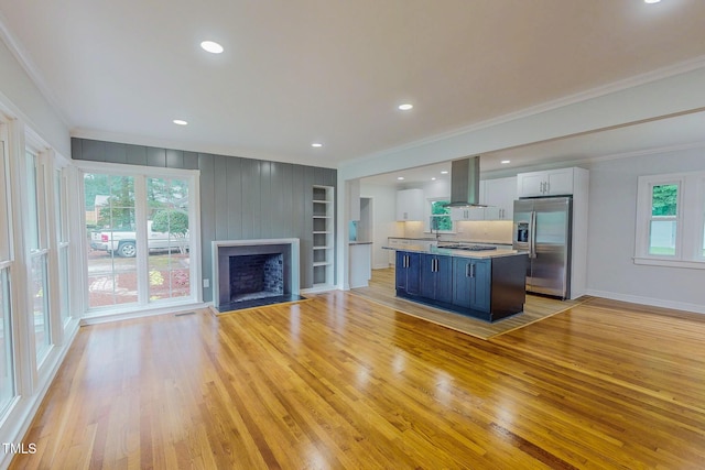 303 Winhaven St, Roxboro, NC 27573 - unfurnished living room featuring crown molding, light wood finished floors, a fireplace, built in shelves, and recessed lighting