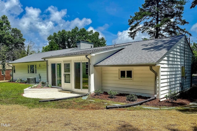 303 Winhaven St, Roxboro, NC 27573 - rear view of house with a shingled roof, a chimney, a patio, and a lawn
