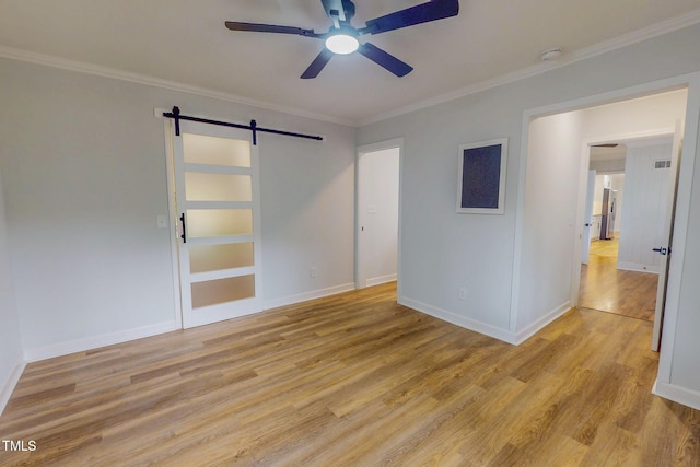 303 Winhaven St, Roxboro, NC 27573 - unfurnished room featuring a barn door, ceiling fan, light wood finished floors, crown molding, and a smoke detector