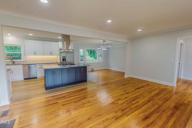 303 Winhaven St, Roxboro, NC 27573 - kitchen with wall chimney range hood, appliances with stainless steel finishes, white cabinetry, crown molding, and light wood finished floors