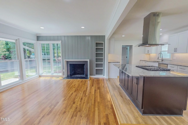 303 Winhaven St, Roxboro, NC 27573 - kitchen featuring island range hood, ornamental molding, gas cooktop, light wood-type flooring, and white cabinetry