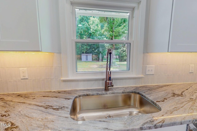 303 Winhaven St, Roxboro, NC 27573 - kitchen view of light stone countertops, tasteful backsplash, and white cabinetry