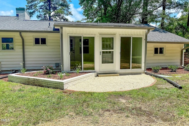 303 Winhaven St, Roxboro, NC 27573 - back of property with a chimney, roof with shingles, a patio area, and a lawn