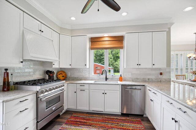 633 Fleming Rd, Youngsville, NC 27596 - kitchen featuring stainless steel appliances, custom range hood, ceiling fan, ornamental molding, and white cabinetry