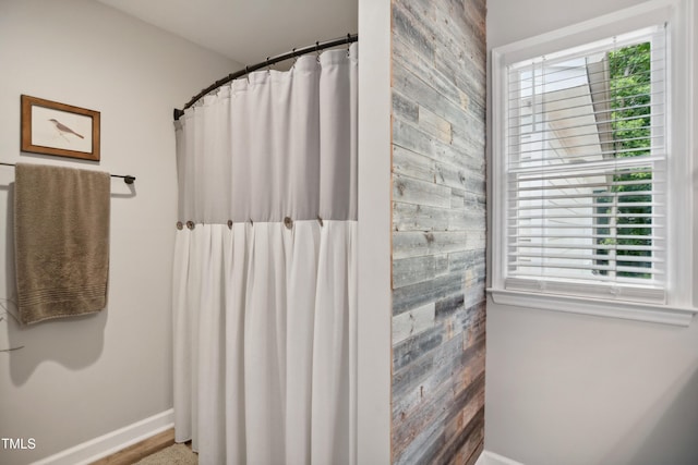 633 Fleming Rd, Youngsville, NC 27596 - bathroom featuring plenty of natural light, wooden walls, a shower with curtain, and an accent wall
