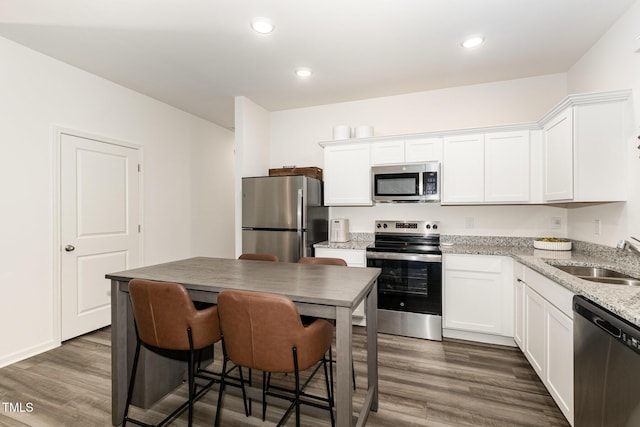 2050 Trailside Dr, Durham, NC 27704 - kitchen with stainless steel appliances, white cabinetry, dark wood finished floors, recessed lighting, and light stone countertops